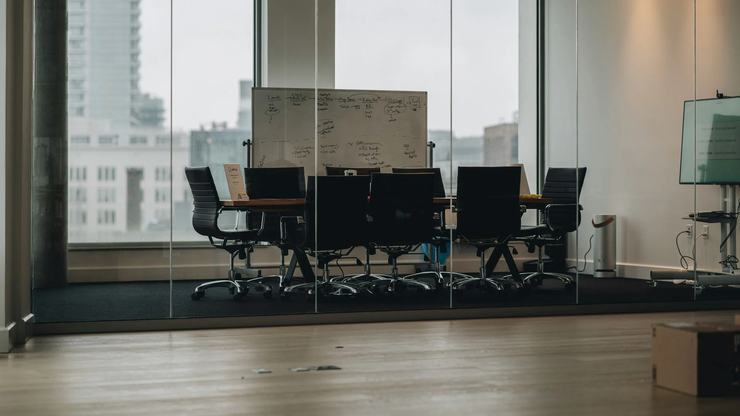 A glass-walled meeting room with a whiteboard