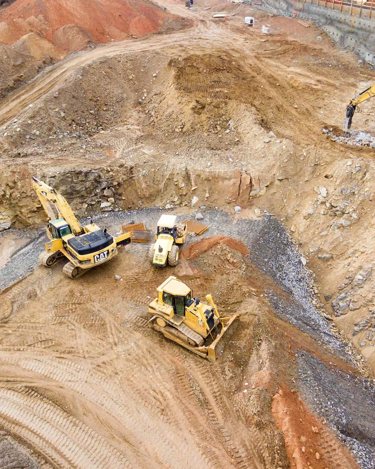 Earth-moving machines in an open pit seen from above