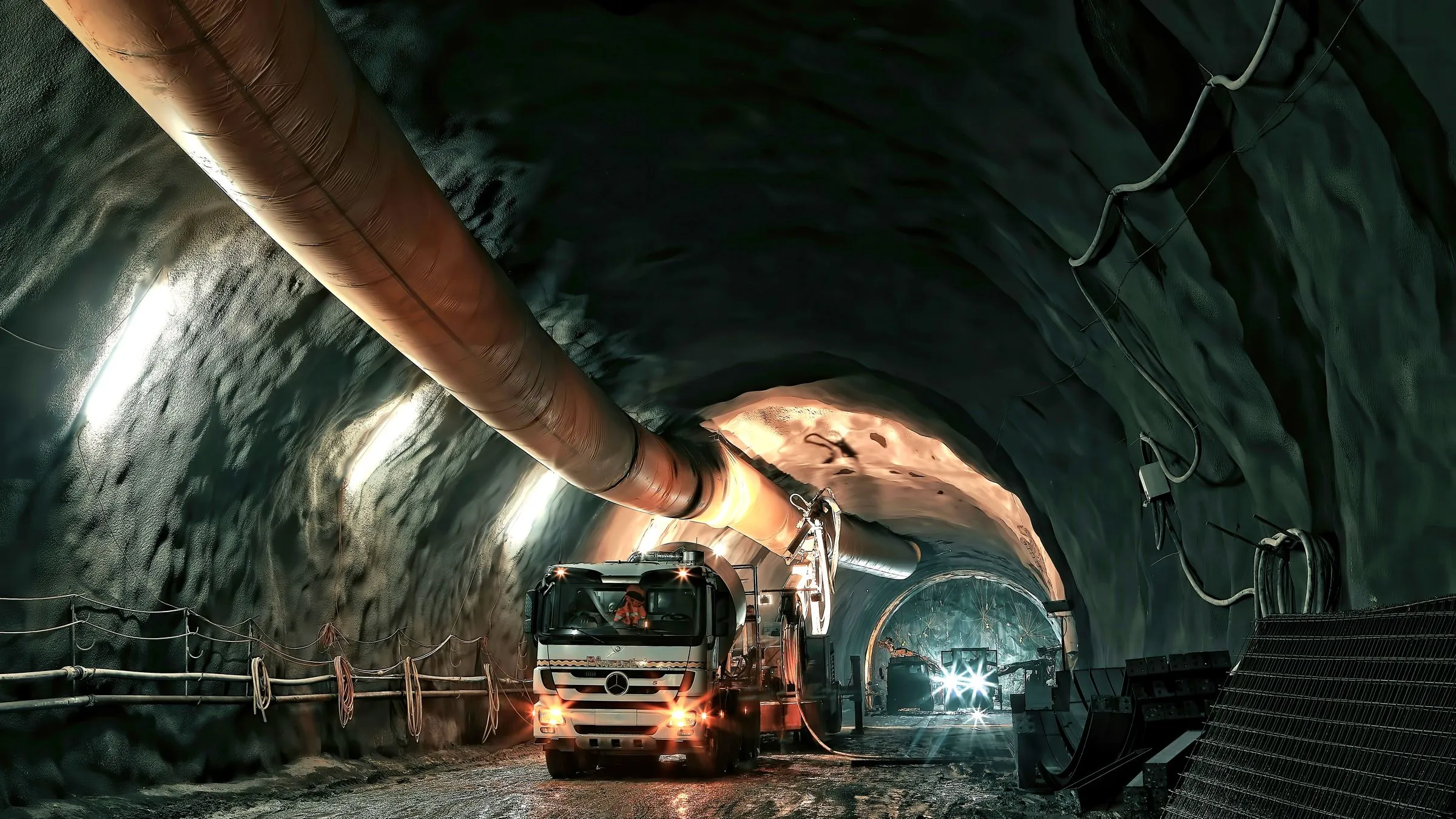 A truck working in a lit mine tunnel